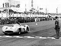 Grosser Preis von Italien in Monza, 11. September 1955. Juan Manuel Fangio (Startnummer 18) auf Mercedes-Benz Formel-1-Rennwagen W 196 R mit Stromlinienkarosserie fährt als Sieger durchs Ziel, gefolgt von Piero Taruffi mit Mercedes-Benz W 196 R Monoposto.